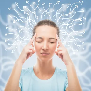 woman holding her temples trying to concentrate which neurofeedback training can help with