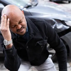 Man holding his head in pain after car accident