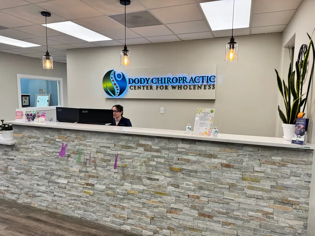 Reception desk with the Dody Chiropractic Center for Wholeness sign in Littleton, Colorado